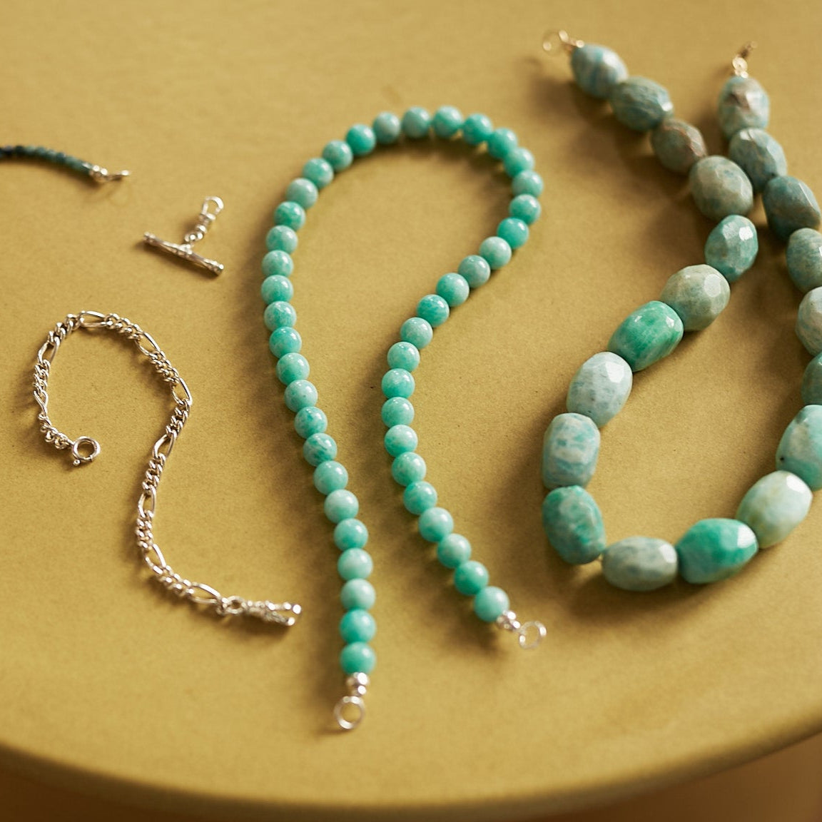 Set of beaded necklaces on a beige surface